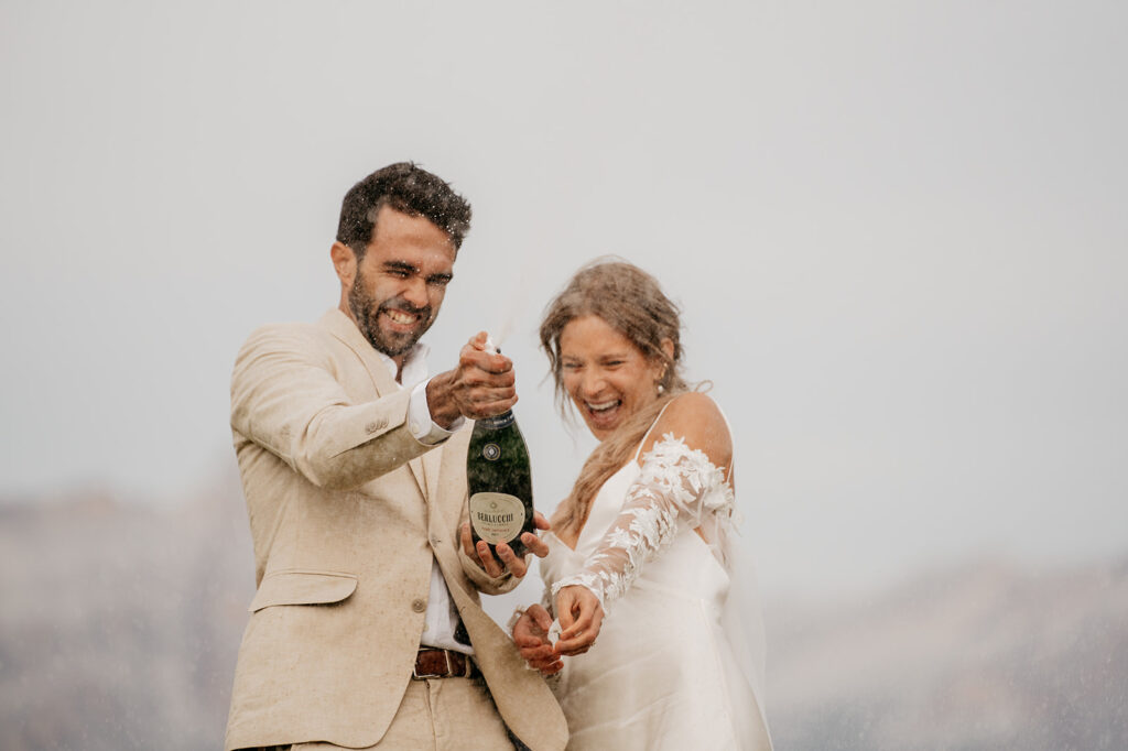 Couple celebrating with champagne outdoors.