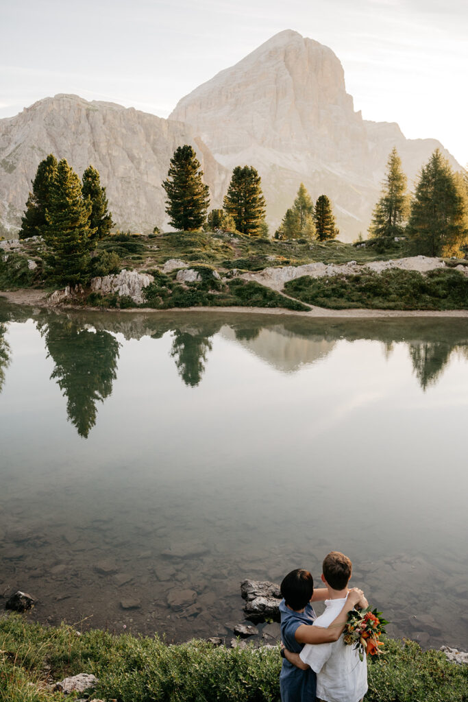 Couple embraces by mountain lake view.