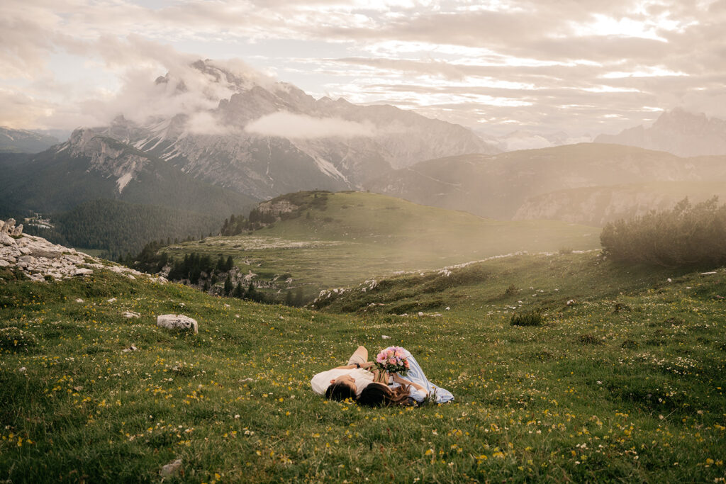 Couple relaxing in mountain meadow with flowers.