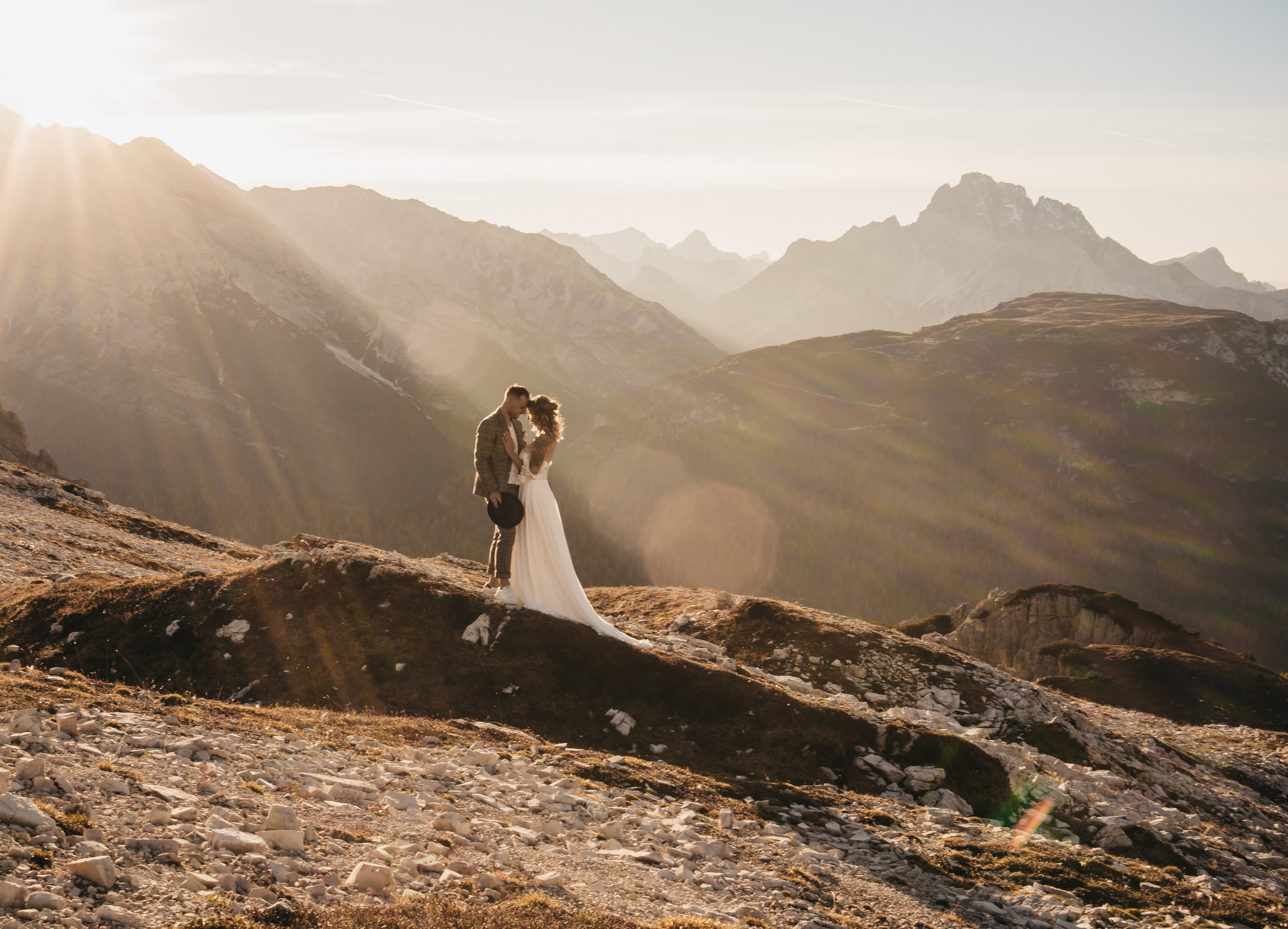 Couple kissing on mountain at sunset.