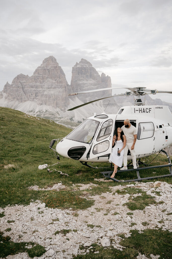 Couple exiting helicopter near mountains