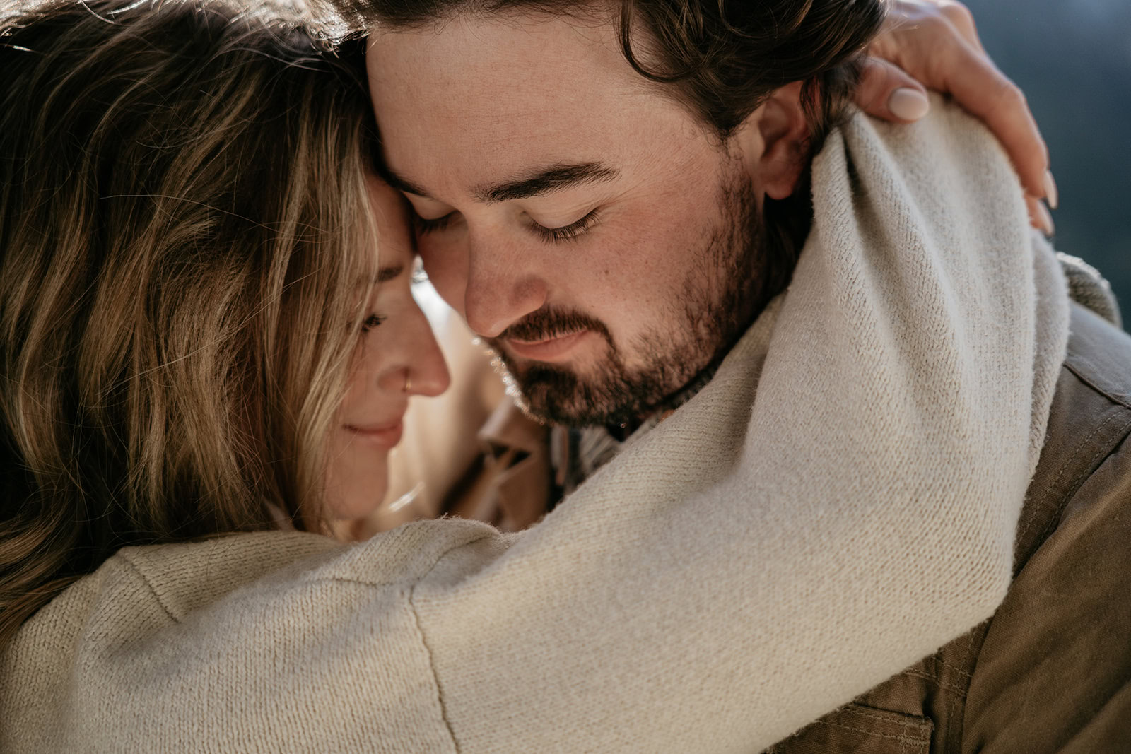 Couple embracing warmly, smiling gently.