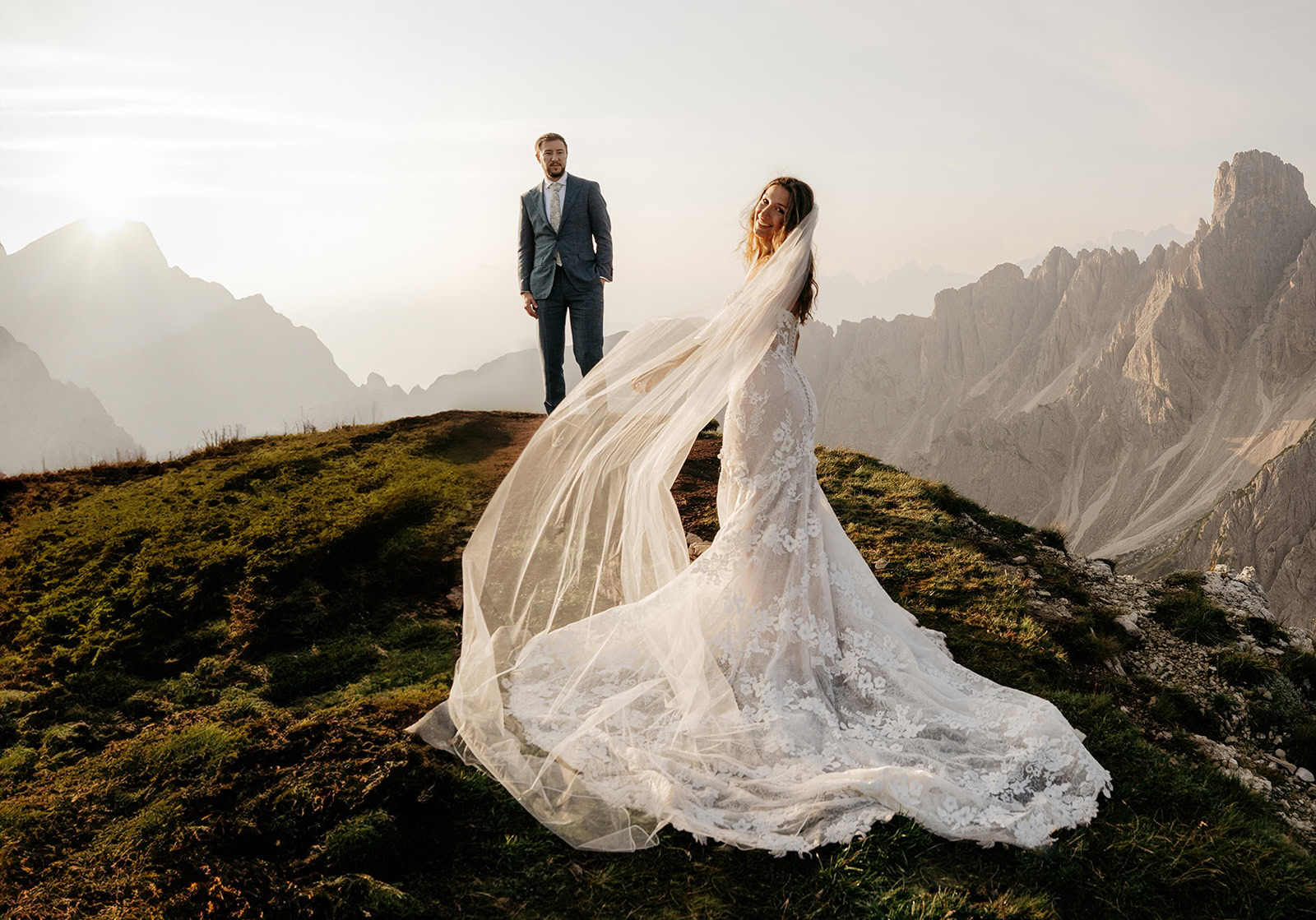 Bride and groom on mountain at sunset.