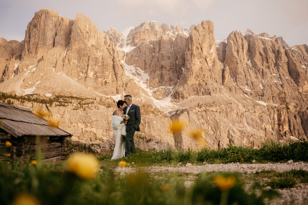 Couple posing by mountainous landscape at sunset.