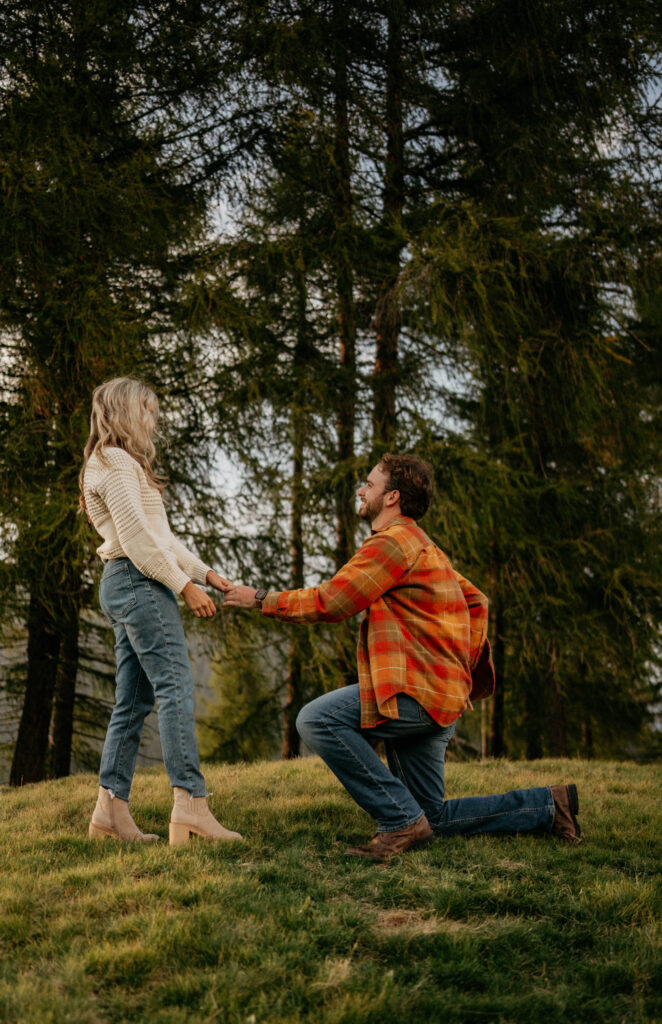 Man proposing to woman in forest setting.