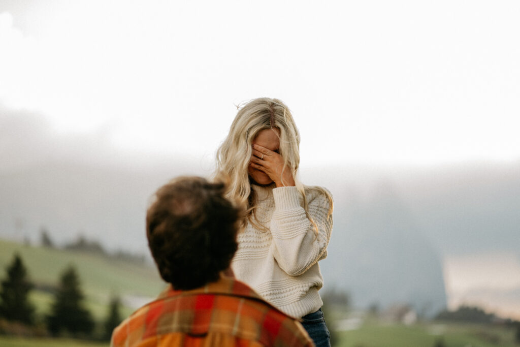 Surprised woman covering face outdoors proposal