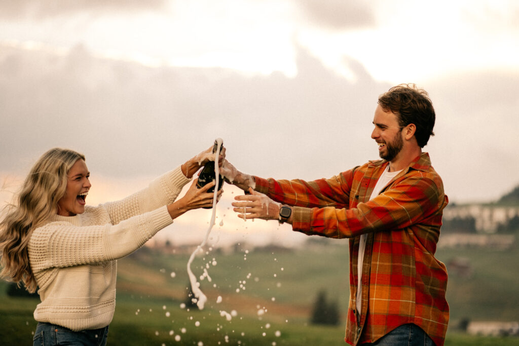 Couple celebrating with champagne outdoors.