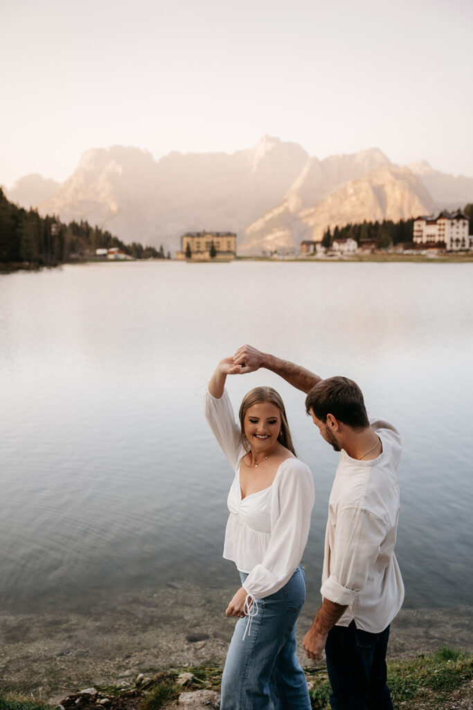 Couple dancing by a scenic mountain lake.