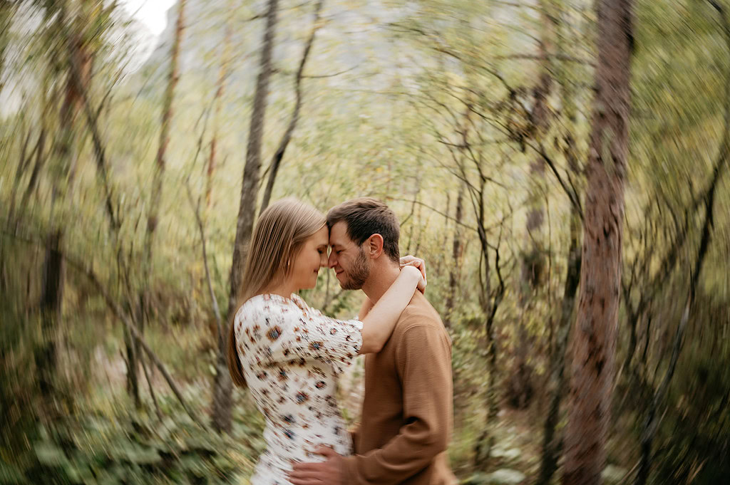 Couple embracing in forest with blurred background