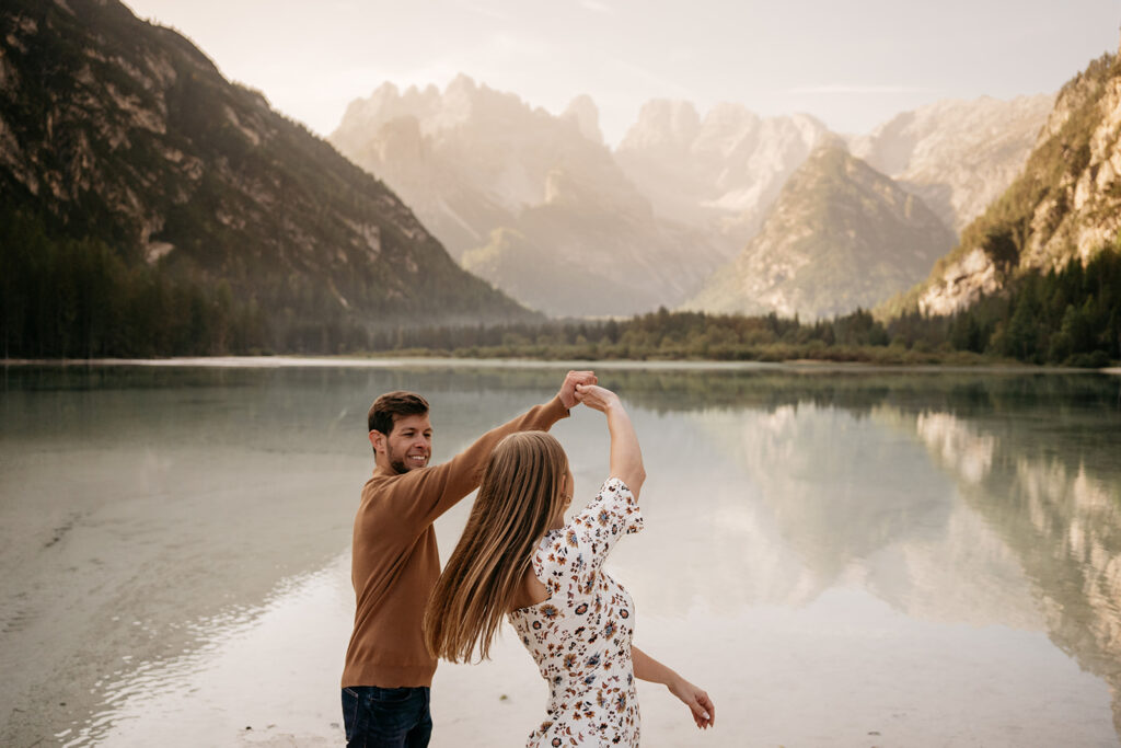 Couple dancing by a serene mountain lake.