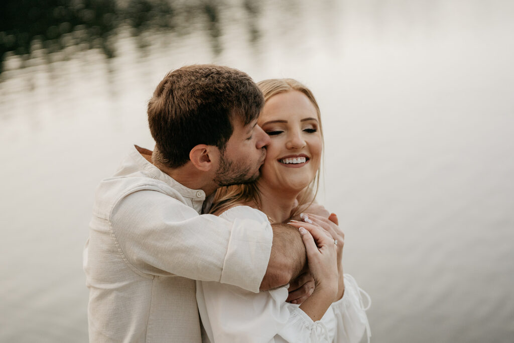 Couple embracing and smiling by a lake