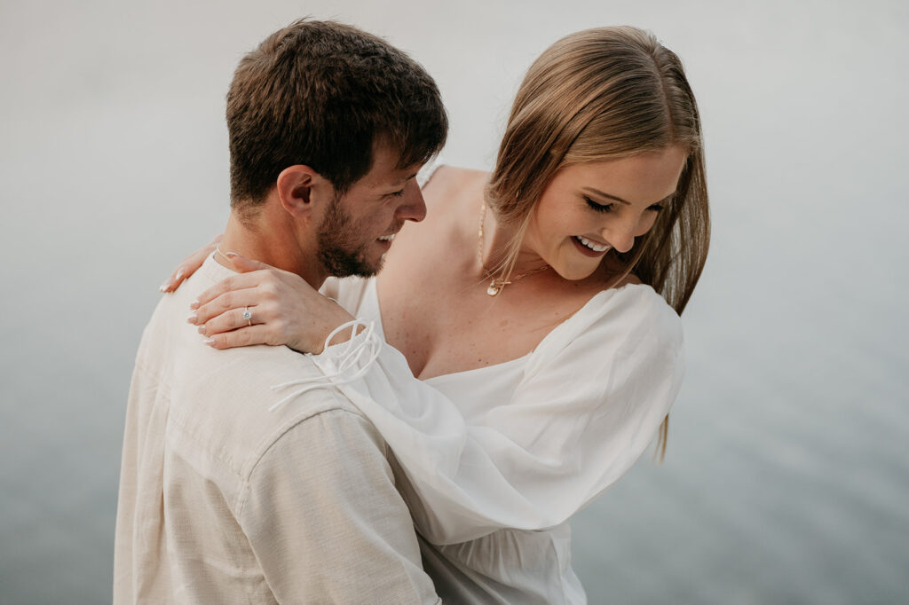 Couple smiling and embracing near water