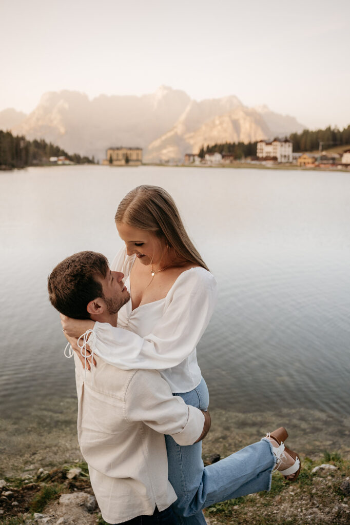 Couple embracing by serene mountain lake