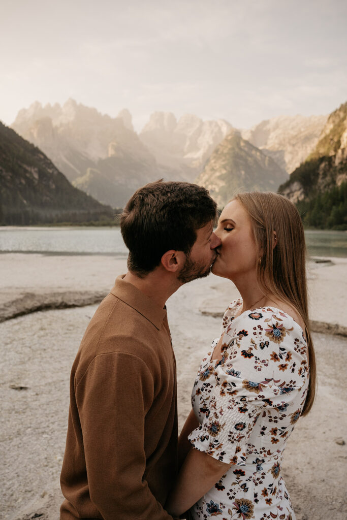 Couple kissing by a mountain lake