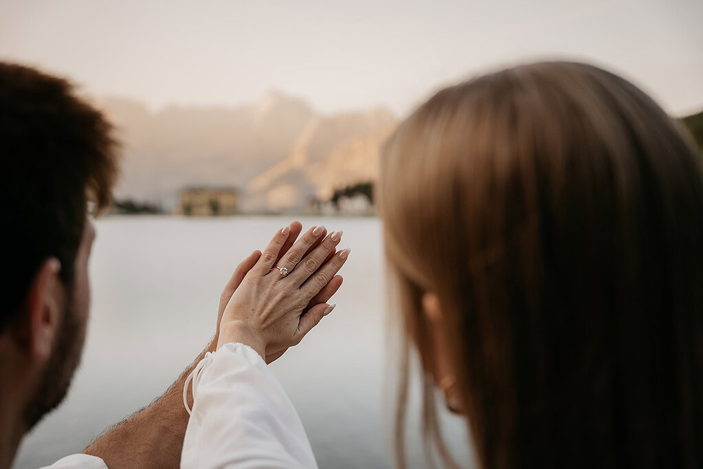 Couple holding hands, engagement ring visible