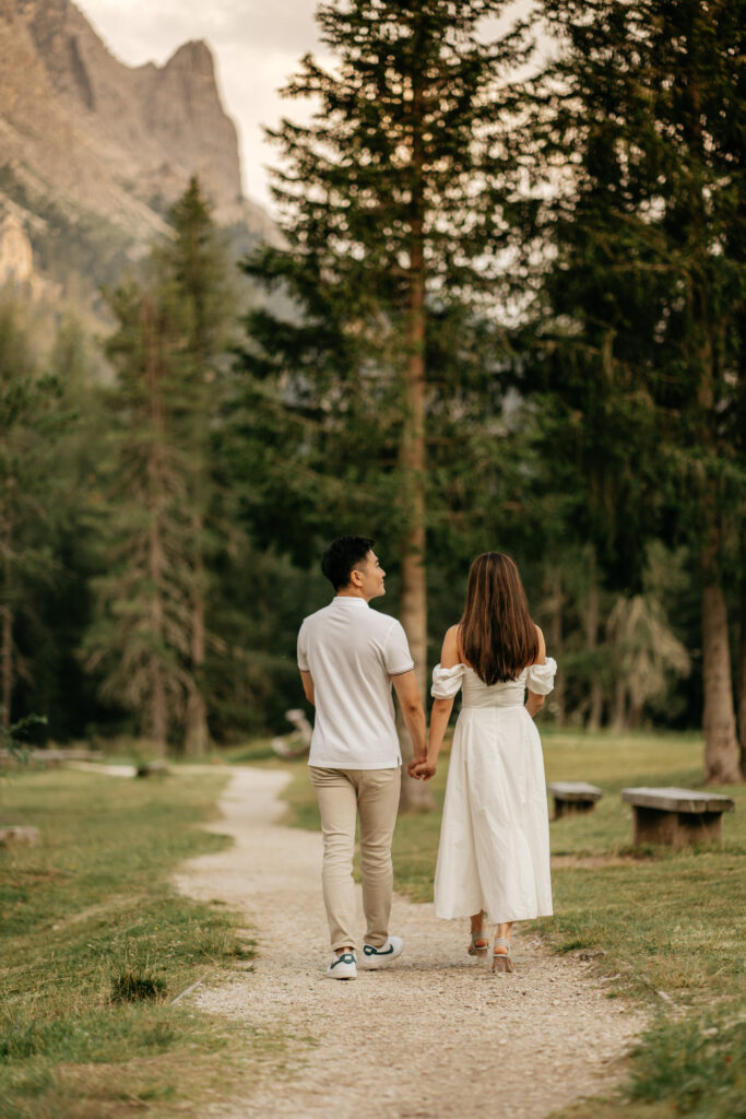 Couple walking on forest path hand in hand.