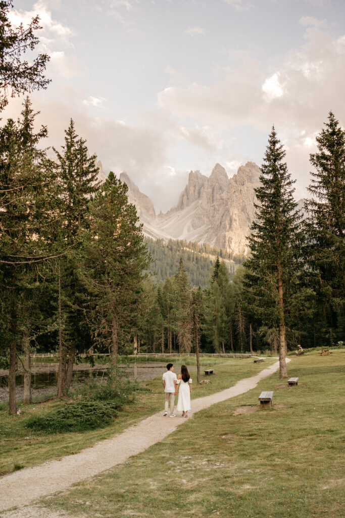 Couple walking along path in scenic mountainous forest.