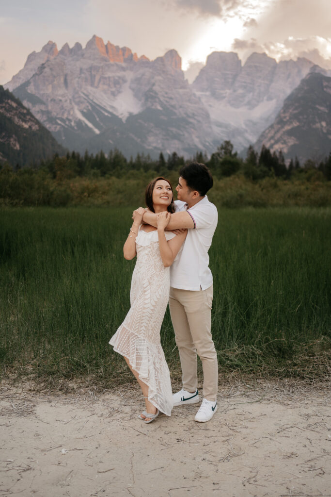 Couple embracing with mountains in the background.