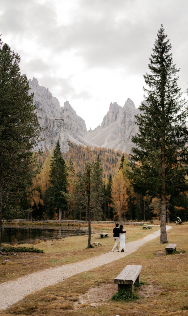 Couple walking on path in mountain landscape.