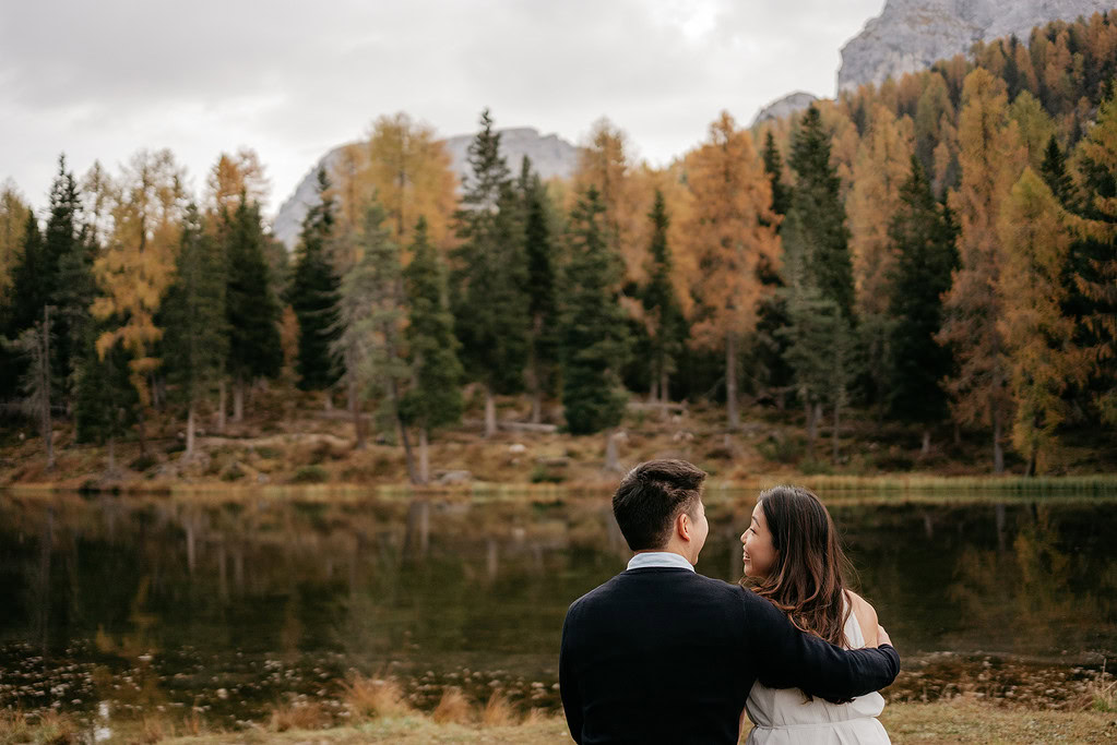 Couple embraces by autumn forest lake