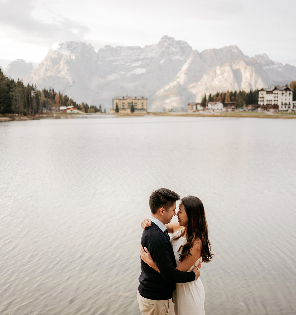 Couple embracing by a serene mountain lake