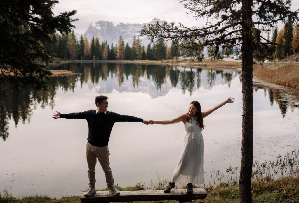 Couple holding hands by a mountain lake