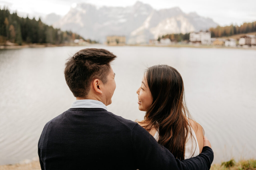 Couple embracing by a serene mountain lake