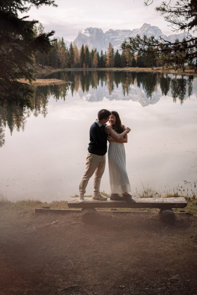 Couple embracing by a scenic lake view.