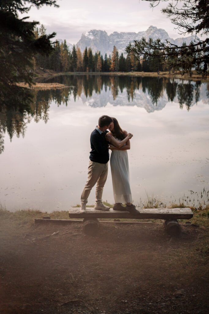 Couple embracing by a scenic mountain lake.