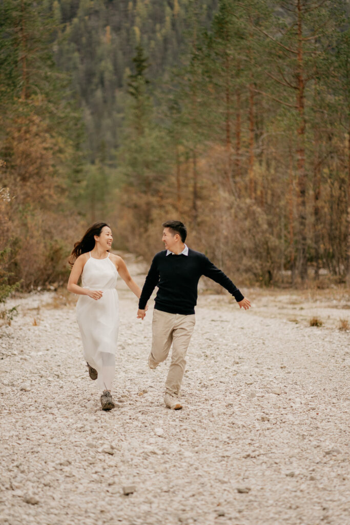 Couple joyfully running on a rocky path