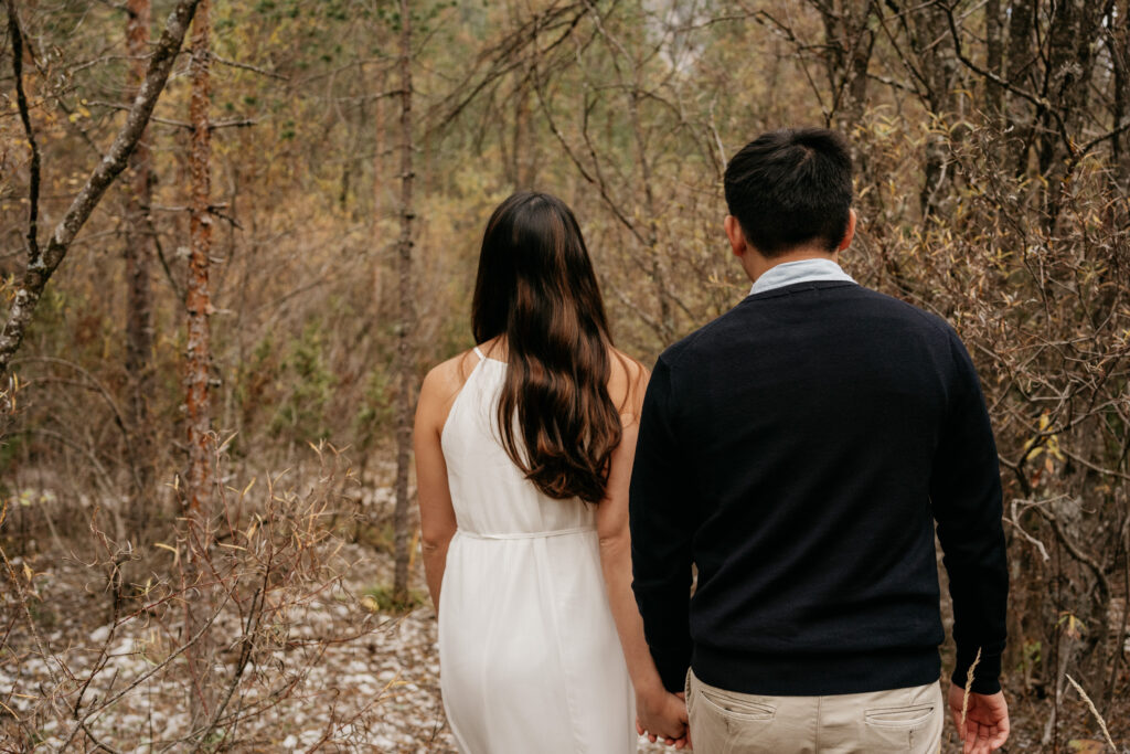 Couple holding hands walking in forest