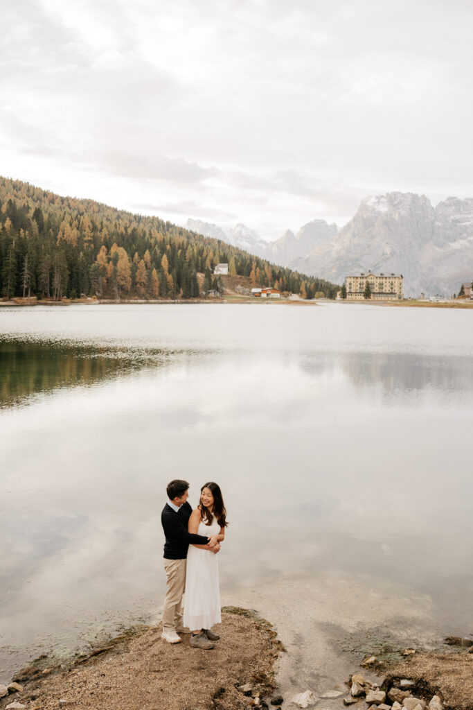 Couple embracing by a serene mountain lake