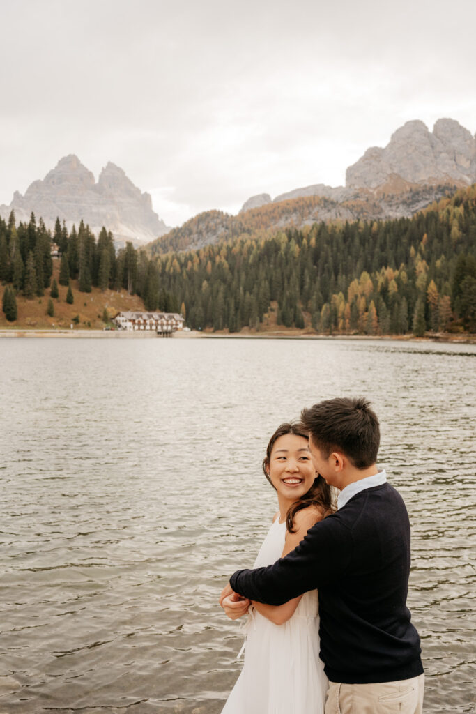 Couple embracing by a mountain lake