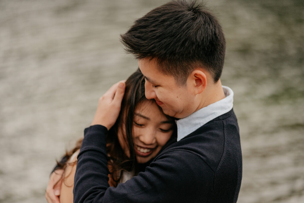 Couple embracing by the water