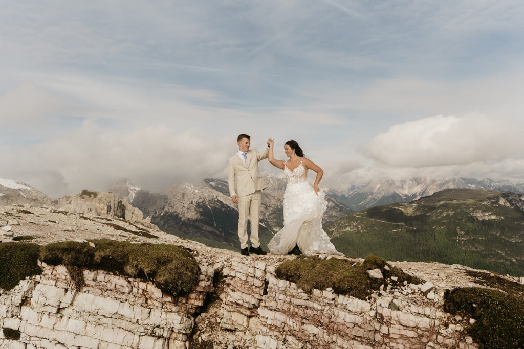 Couple dancing on mountain cliff.