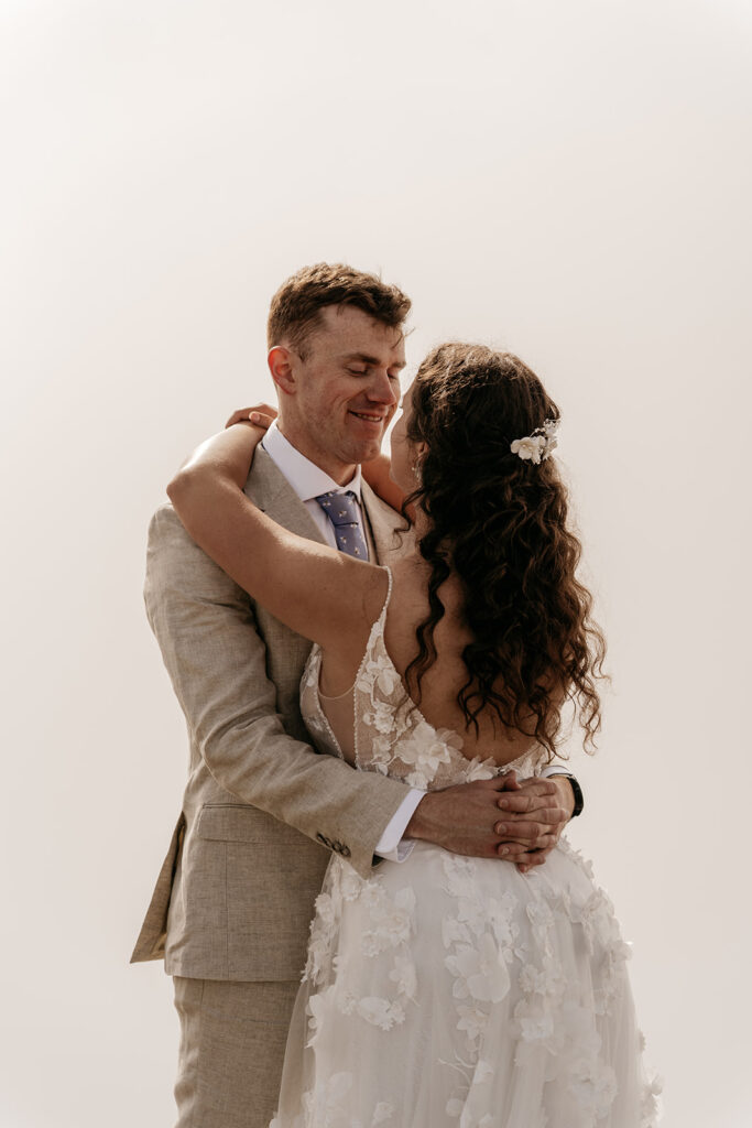 Bride and groom embracing on wedding day.