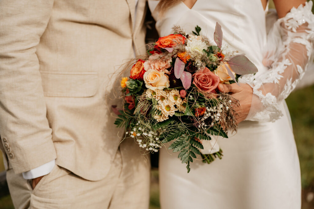 Wedding couple holding floral bouquet together