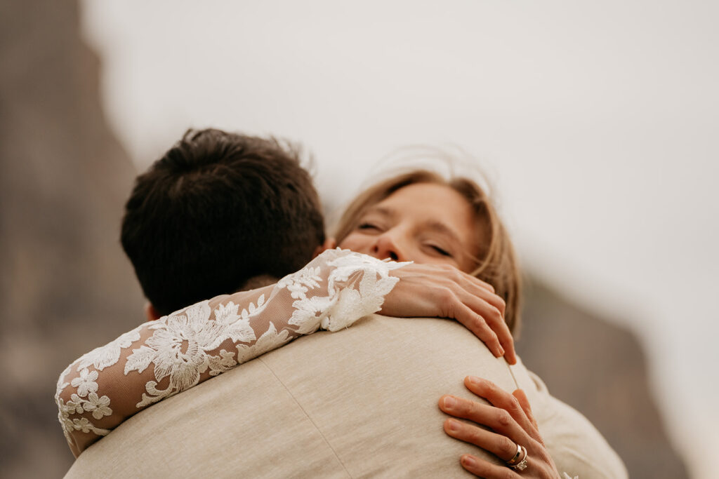 Bride embracing groom in heartfelt hug.