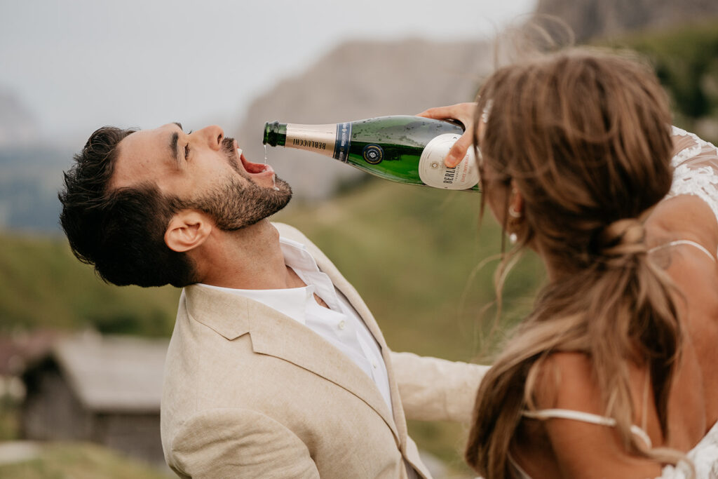 Man drinking champagne from bottle outdoors