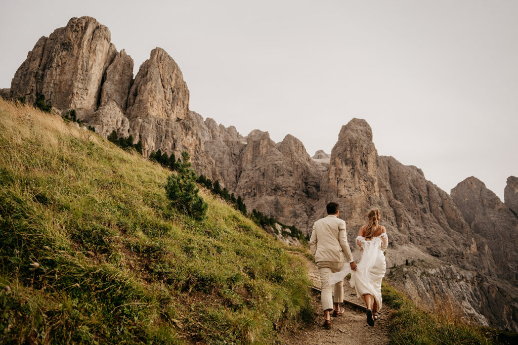 Couple hiking in mountains, dressed elegantly.