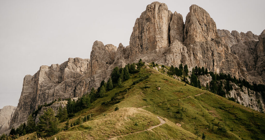 Mountain landscape with rocky peaks and green hills.