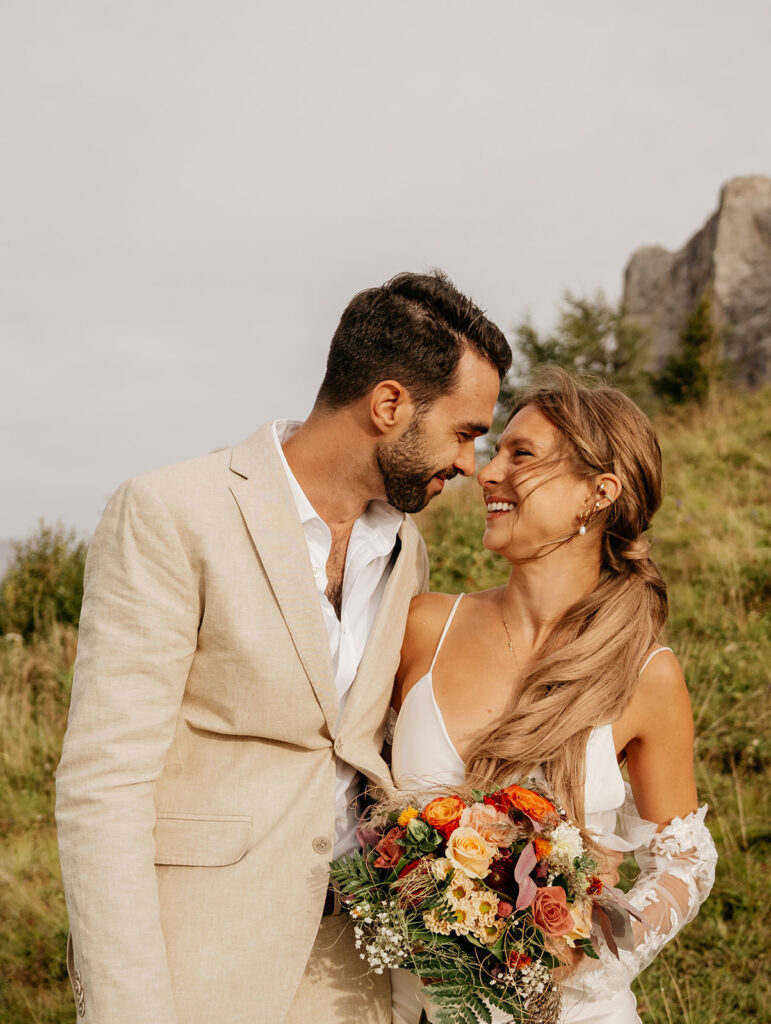 Smiling couple holding bouquet outdoors