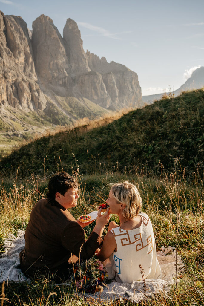 Couple enjoys picnic with mountain view.