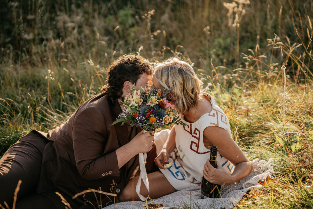 Couple sharing flowers at outdoor picnic