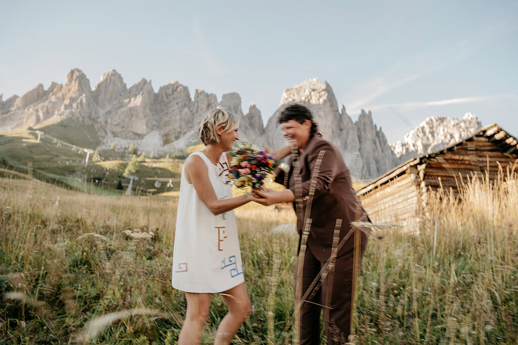 Happy couple with flowers in mountain meadow