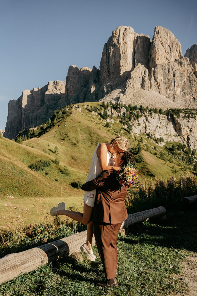 Couple embraces in scenic mountain landscape.