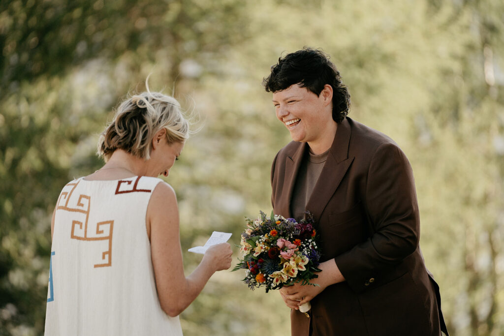 Couple exchanging vows outdoors, smiling brightly