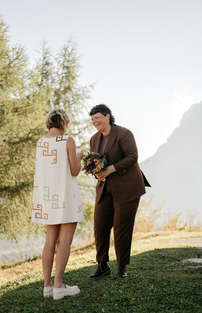 Smiling couple exchanging vows outdoors.