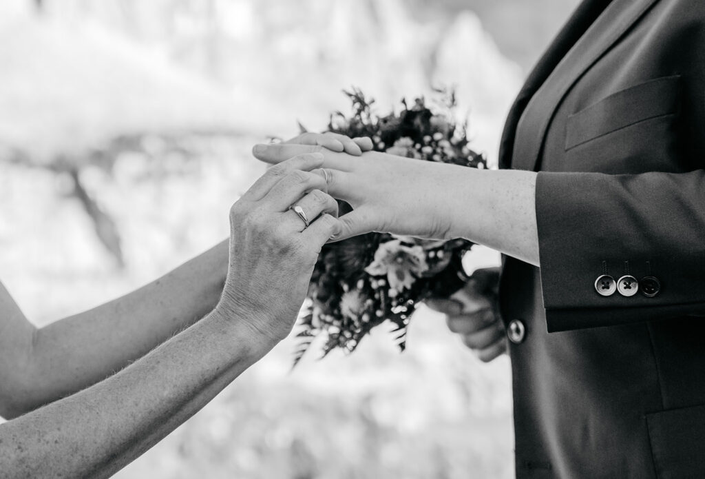 Black and white wedding ring exchange moment.