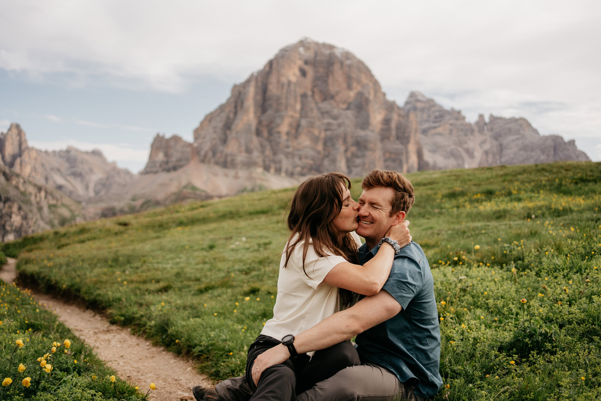 Couple embracing in a mountain meadow landscape.